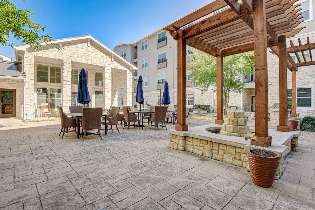 a patio with tables and chairs and a pergola