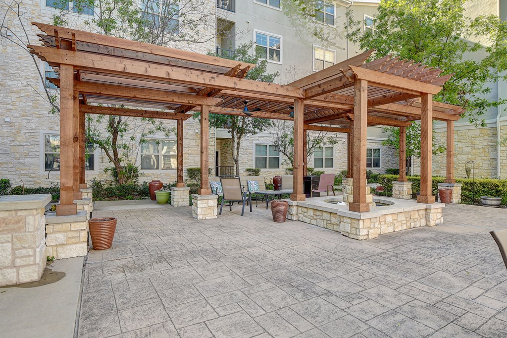 a patio with a pergola and a table and chairs