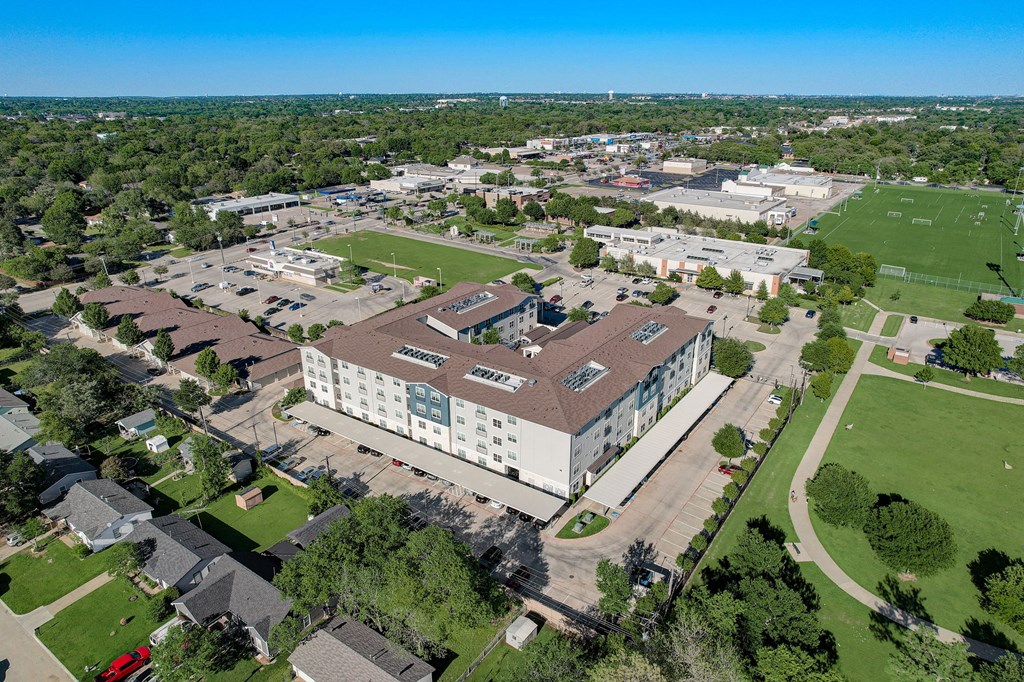 an aerial view of a campus with a building and a field