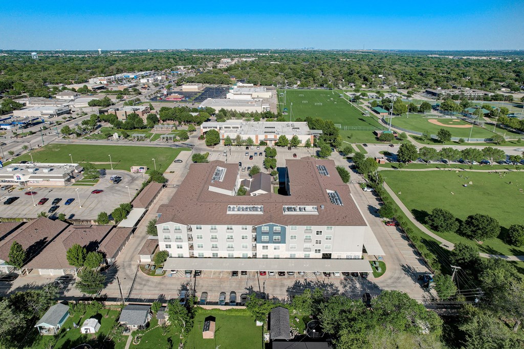 an aerial view of a campus with a field and buildings