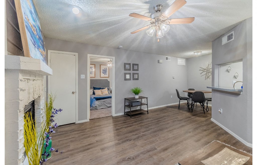 a living room with a fireplace and a ceiling fan