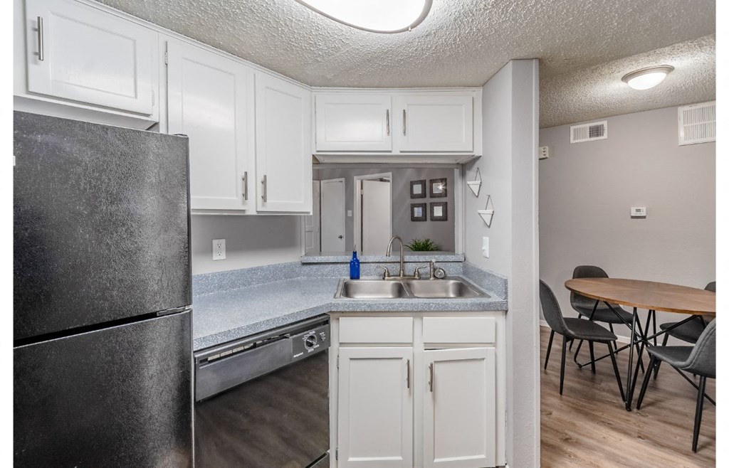 a kitchen with white cabinets and a stainless steel refrigerator
