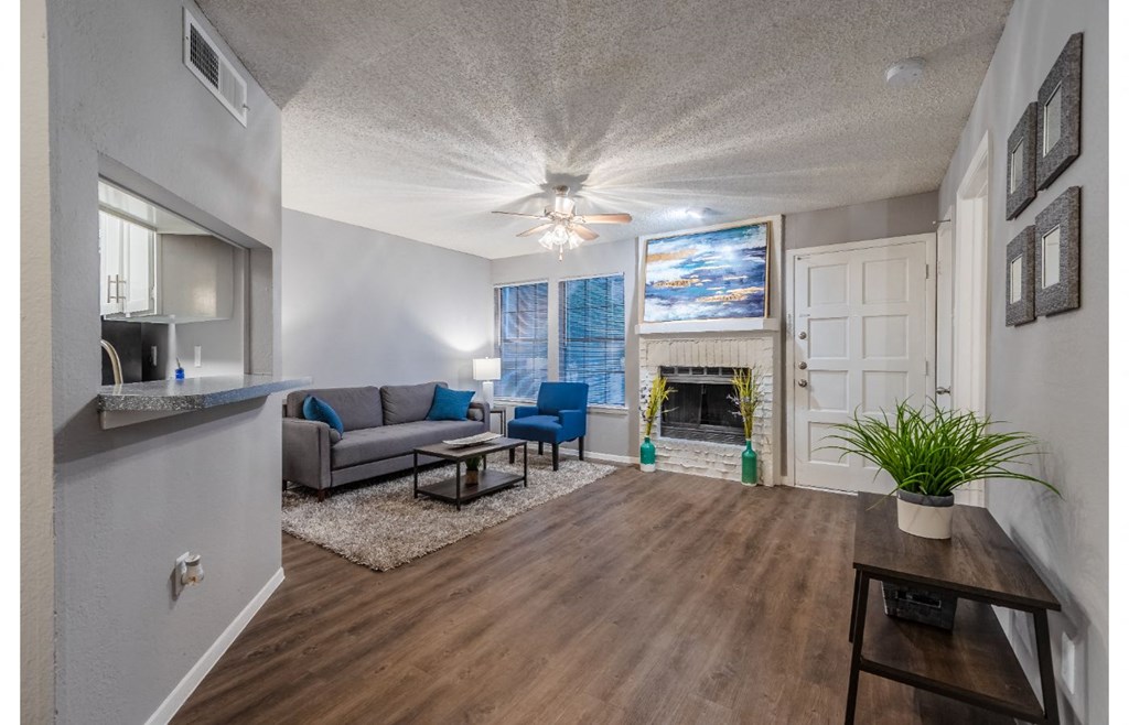 a living room with a fireplace and a ceiling fan