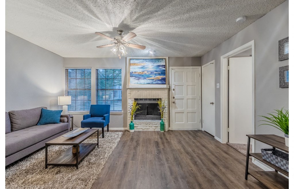 a living room with a fireplace and a ceiling fan