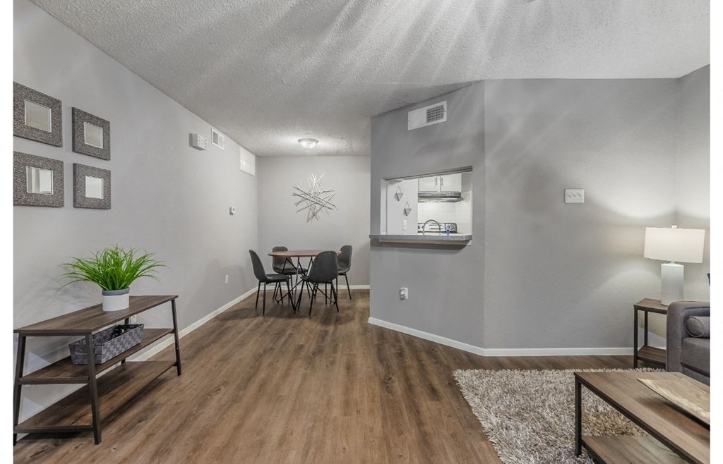 the living room and dining area of a house with a table and chairs