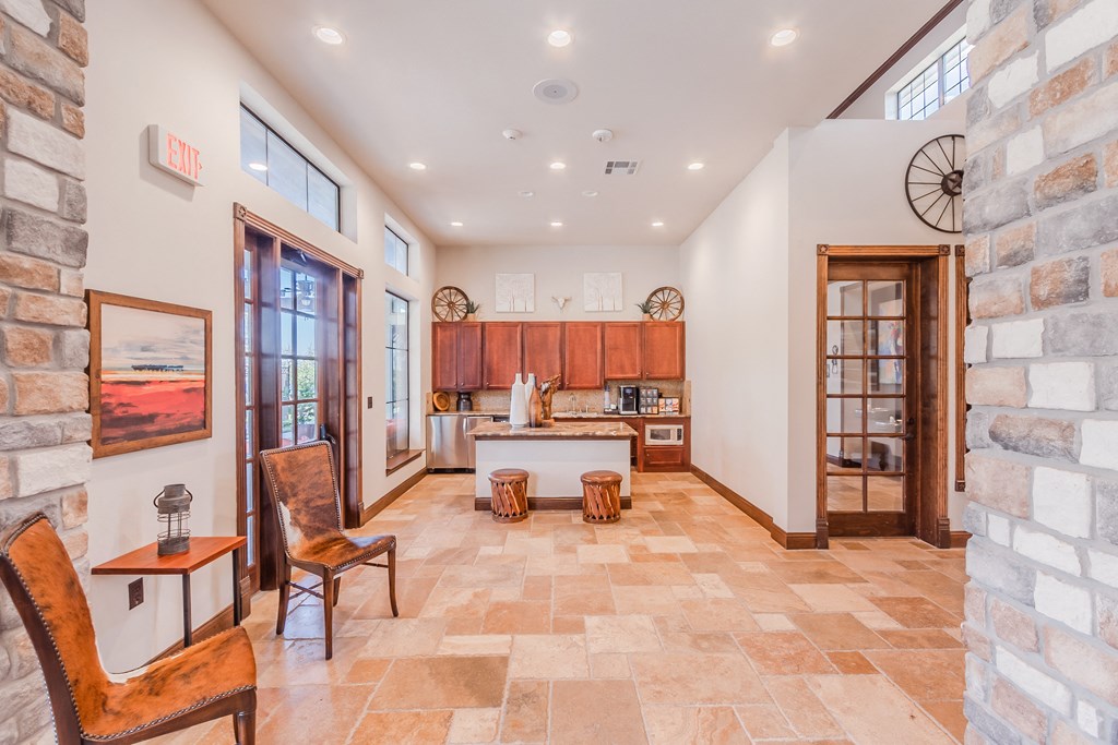 a large living room with a kitchen and a stone wall