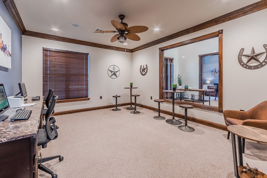 a home office with a computer desk and a ceiling fan