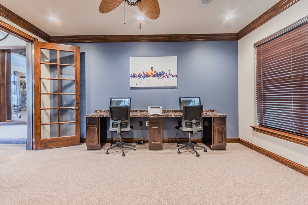 a home office with two desks and two computer monitors