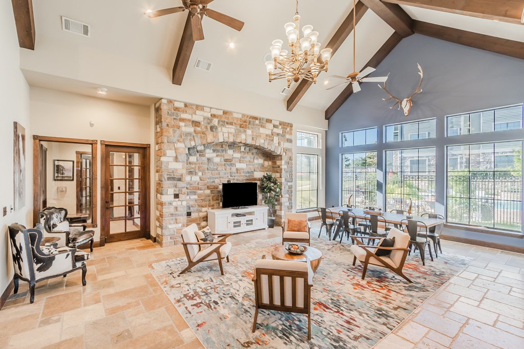 a large living room with a stone fireplace and a dining room