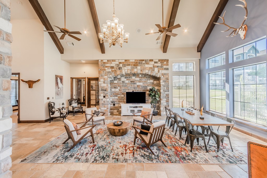 the living room of a house with a stone fireplace and a dining table and chairs