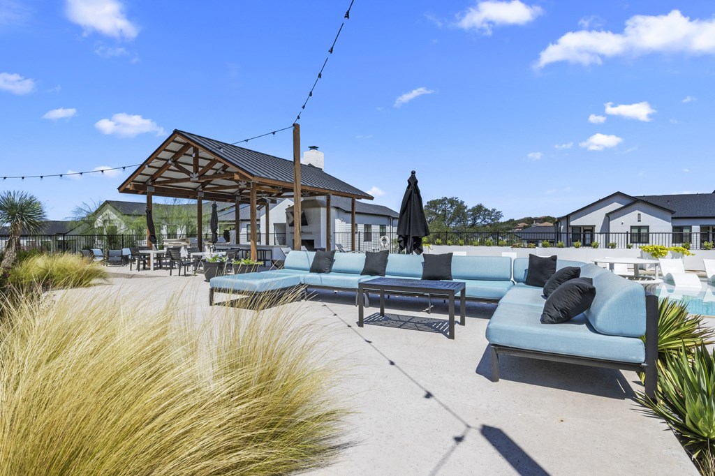 a patio with couches and tables and a pavilion