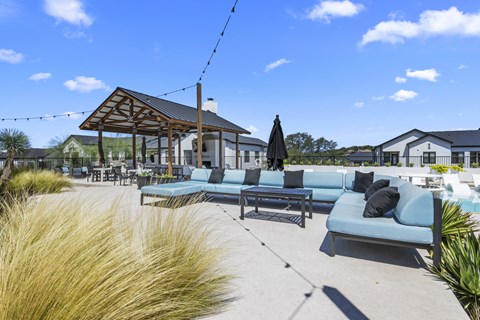 a patio with couches and tables and a pavilion