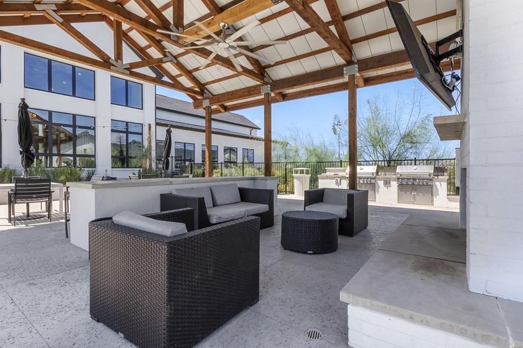 a patio with couches and chairs and a building in the background