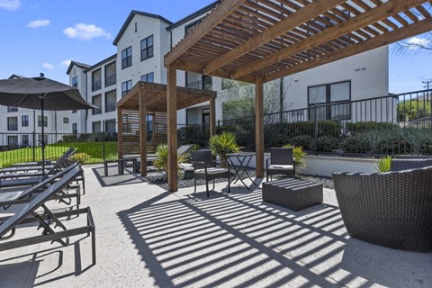 a patio with tables and chairs and a pergola