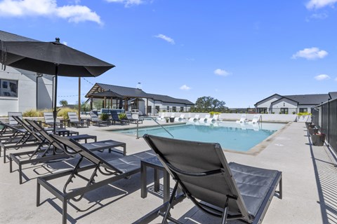 our resort style pool is equipped with lounge chairs and umbrellas