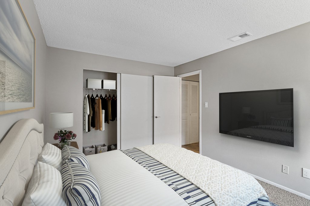 a bedroom with a large bed and a tv on the wall