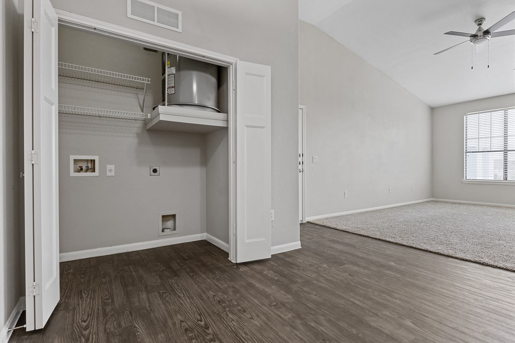 the living room of an empty apartment with wood flooring and a ceiling fan