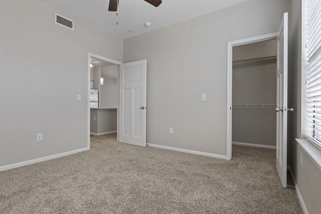 an empty bedroom with a closet and a door to a bathroom
