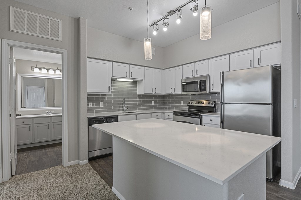 a kitchen with stainless steel appliances and a white counter top