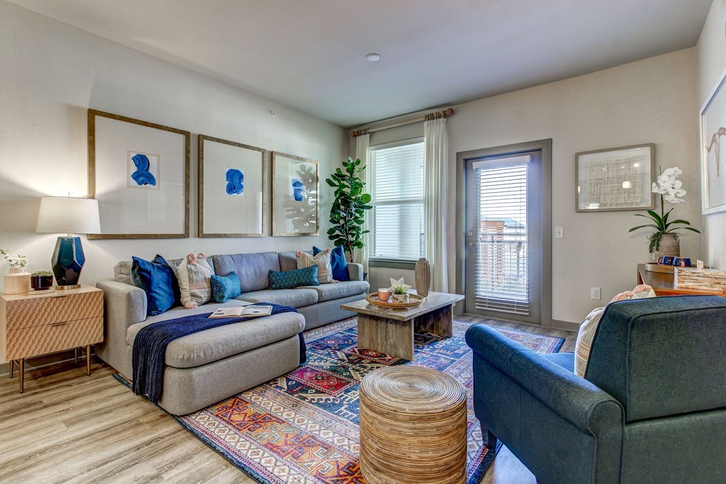 a living room with couches and chairs and a door to a balcony