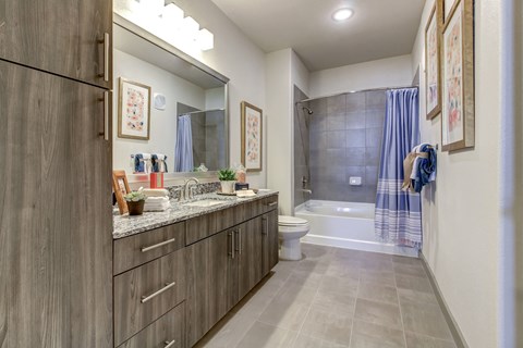 a bathroom with wooden cabinets and a shower and a toilet