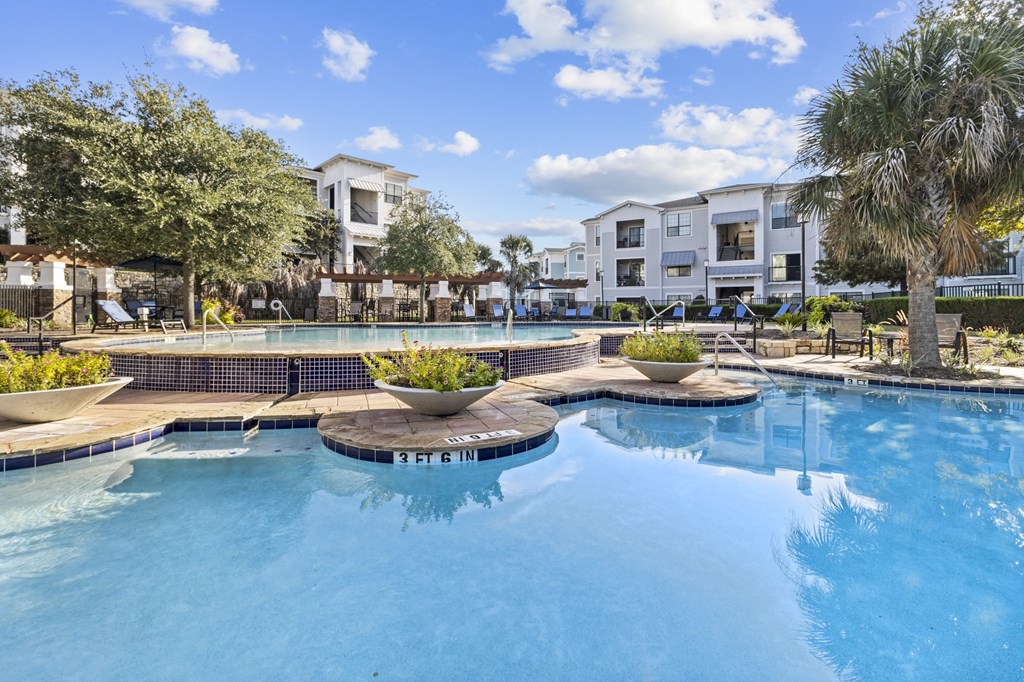 a large swimming pool with apartments in the background