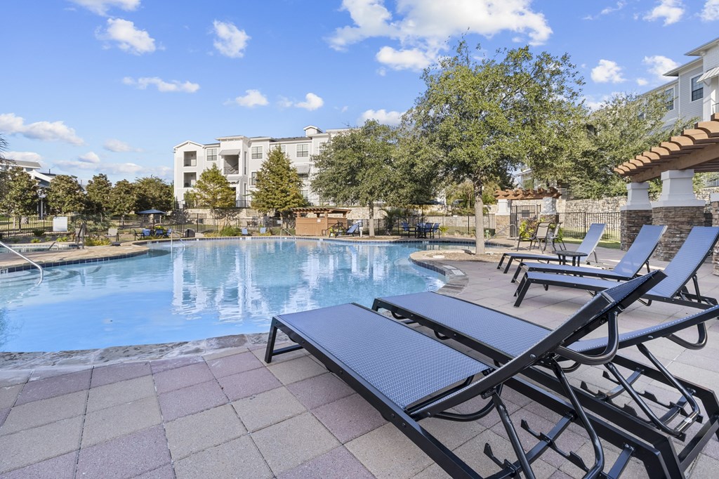 a swimming pool with chaise lounge chairs