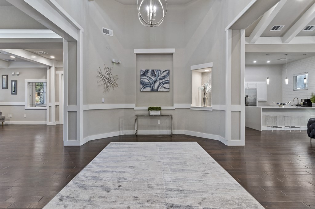 an empty living room with a rug and a table