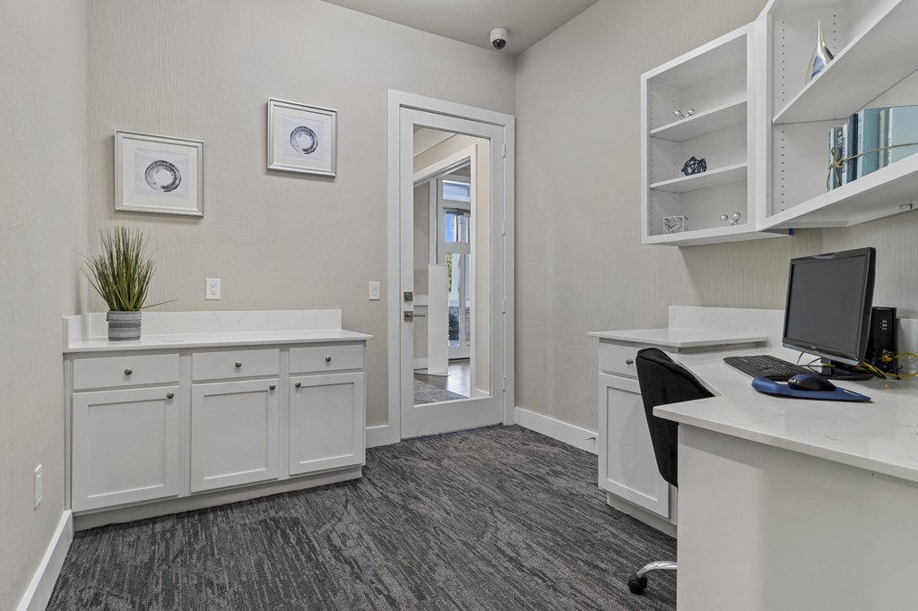 an office with a computer desk and a door to a hallway