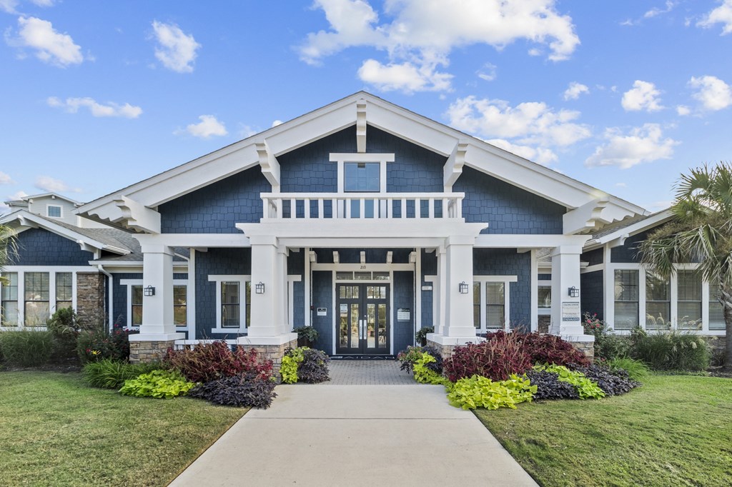 a blue house with a porch and a sidewalk in front of it