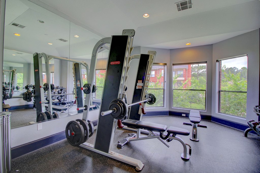 a home gym with weights and a row of windows