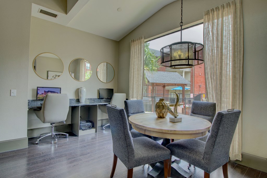a dining area with a table and chairs and a large window