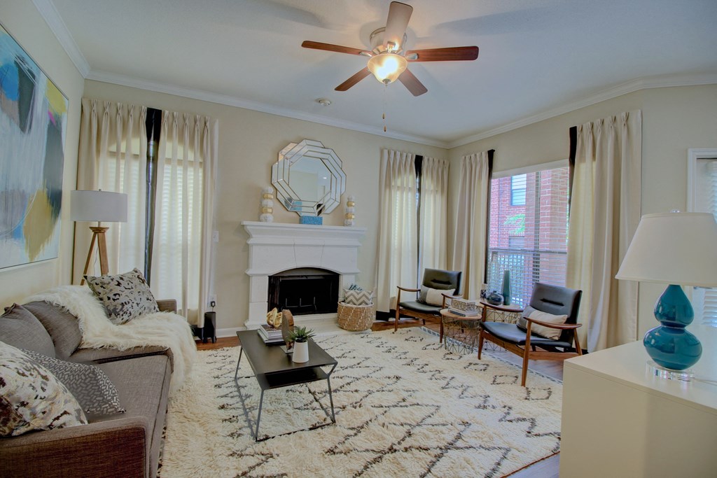 a living room with a fireplace and a ceiling fan