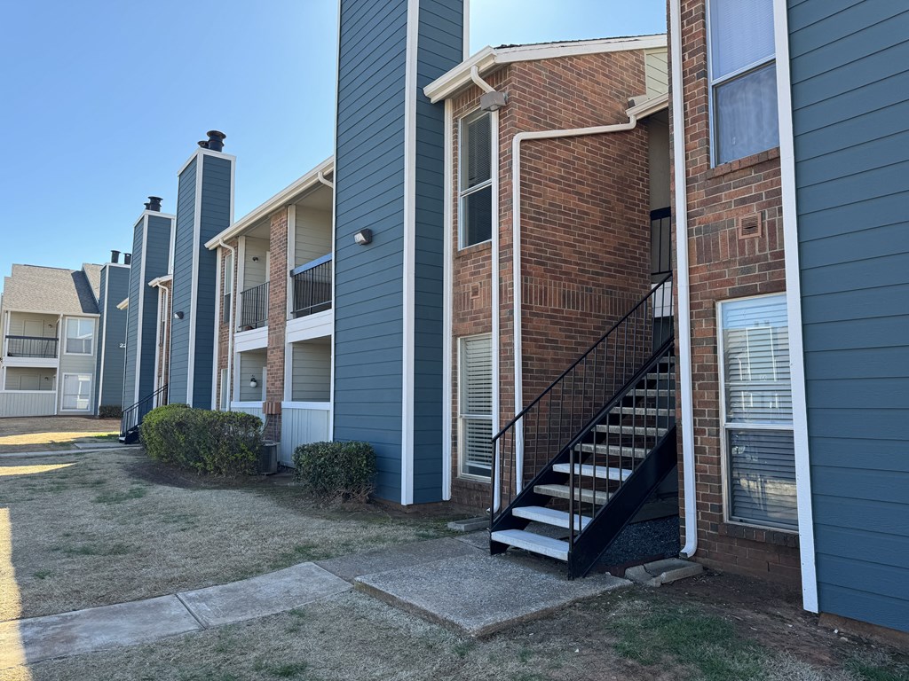 an exterior view of a brick apartment building with stairs