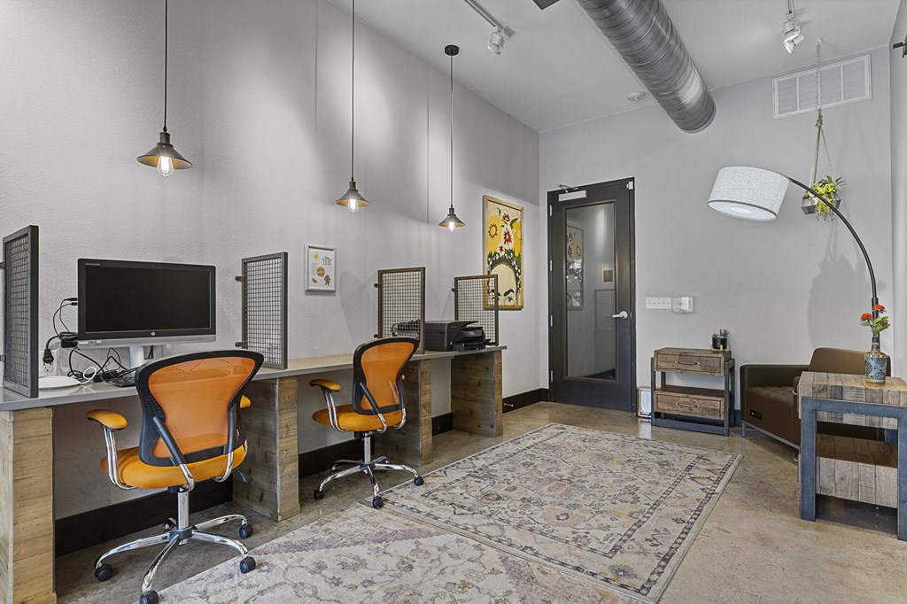 a home office with two desks and a television