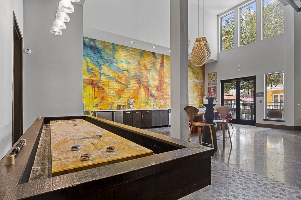 a game room with a pool table and a painting on the wall
