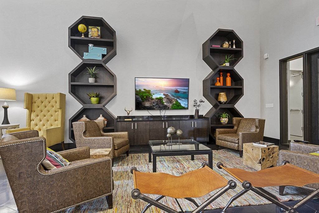 a living room with couches and chairs and a television on the wall