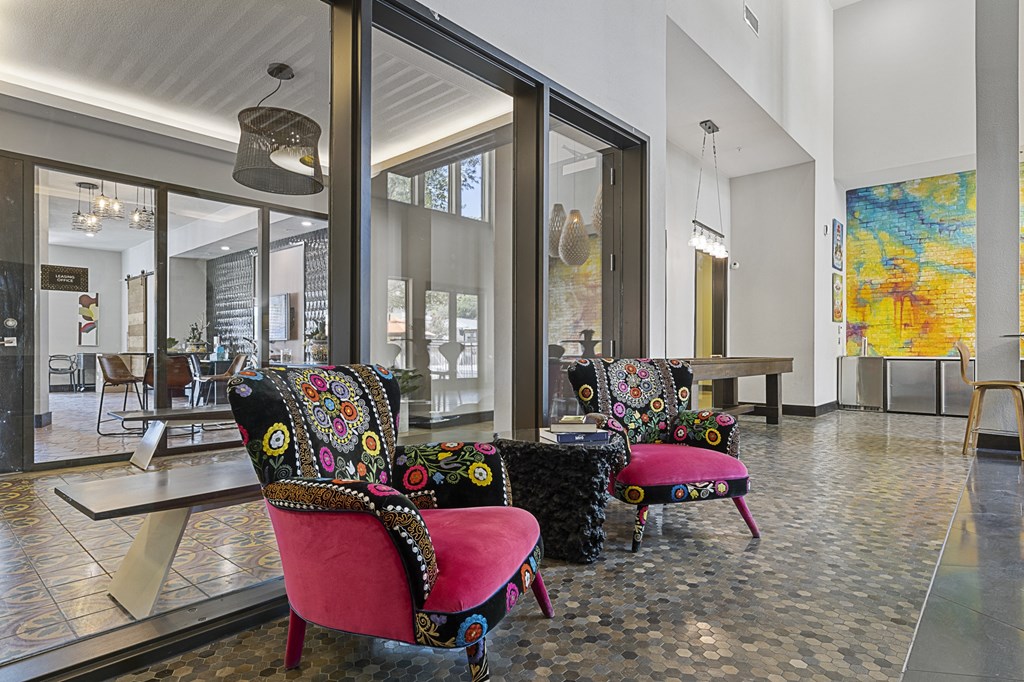 a lobby with chairs and tables and large windows
