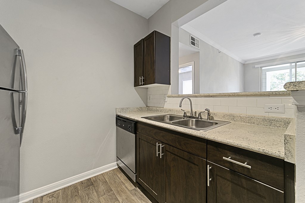 an empty kitchen with a sink and a refrigerator