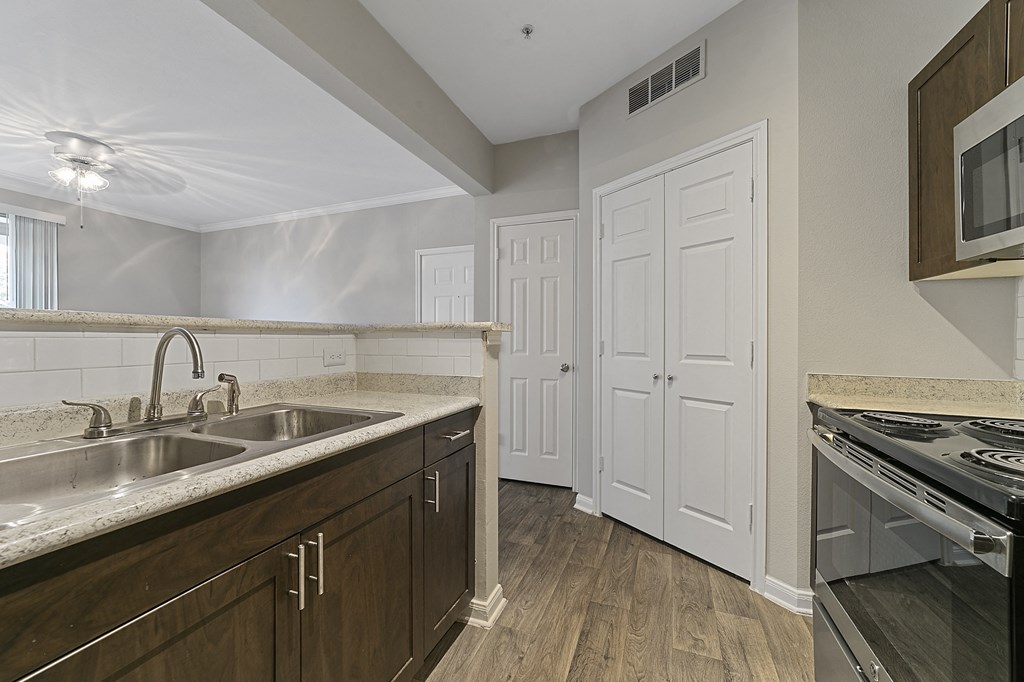 a kitchen with a sink and a stove and a door