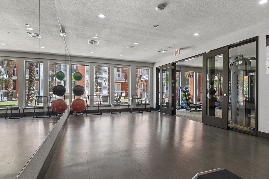 the lobby of a building with glass doors and a gym with spheres on the floor
