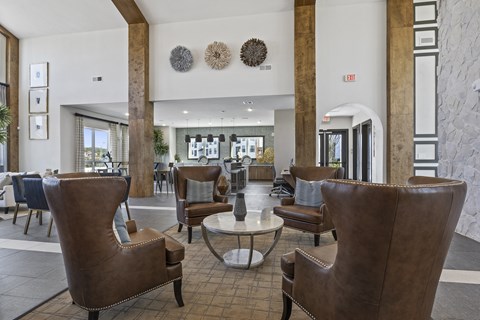 the lobby of a hotel with chairs and tables