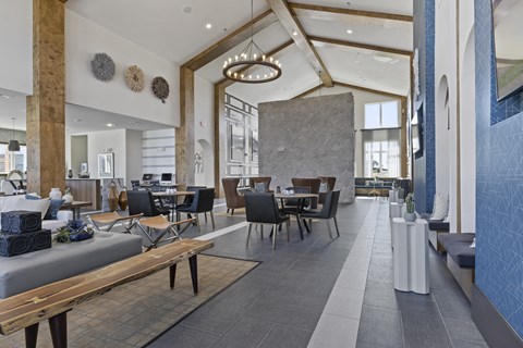 the lobby of a hotel with tables and chairs and a large open space