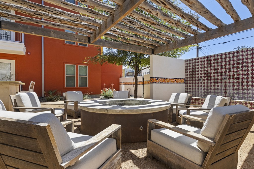 a patio with chairs and a fountain and a pergola