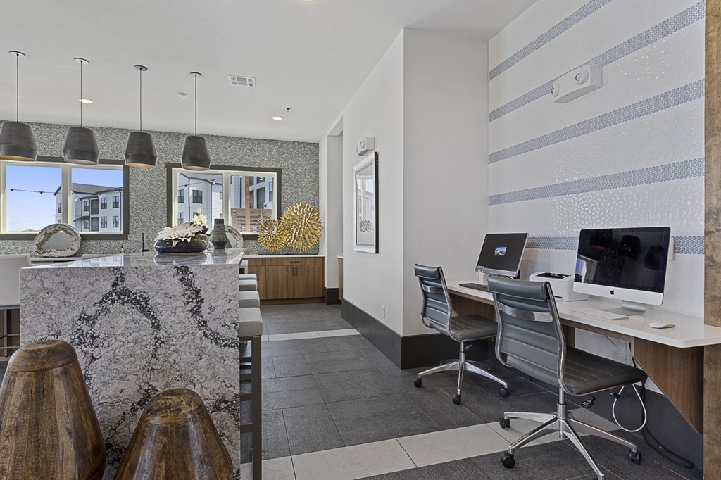 an office with two desks and a counter with chairs and a computer