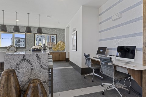 an office with two desks and a counter with chairs and a computer
