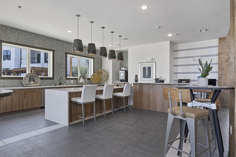 a kitchen with a bar and stools and a dining area