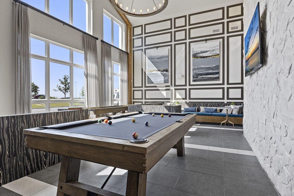 a billiards table in a game room with a large window