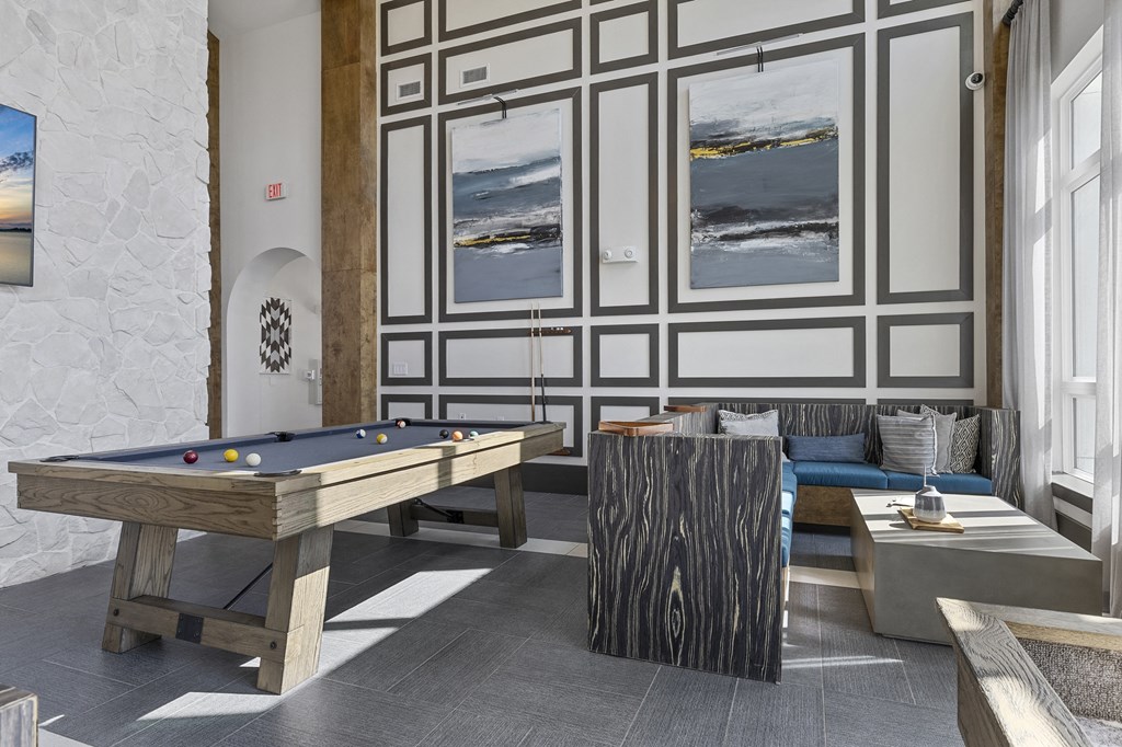 a living room with a pool table and couches