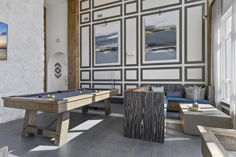a living room with a pool table and couches